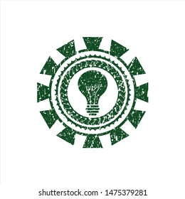 Green light bulb icon inside distressed rubber grunge stamp