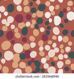 Green, light and maroon rocks simple silhouettes seamless pattern. Doodle masonry print with dark orange background. Decorative backdrop for wallpaper, textile, wrapping, fabric. Vector illustration