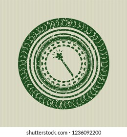 Green magic stick icon inside distressed rubber seal with grunge texture