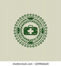 Green medical briefcase icon inside distressed rubber grunge texture stamp