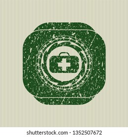 Green medical briefcase icon inside distressed rubber grunge texture seal