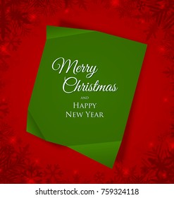 Green Merry Christmas sheet of paper placed on red background with snowflakes