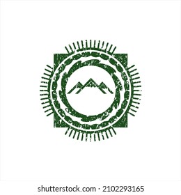 Green mountain icon inside distress rubber seal. 