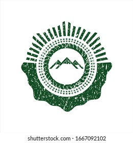 Green mountain icon inside distressed rubber texture