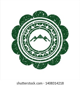 Green mountain icon inside rubber stamp with grunge texture