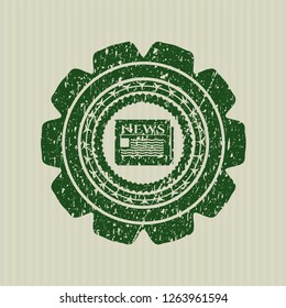 Green newspaper icon inside distressed rubber stamp