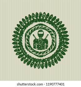 Green ninja icon inside distress rubber stamp with grunge texture