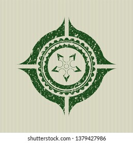 Green ninja star icon inside distress rubber seal