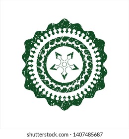 Green ninja star icon inside distressed rubber stamp