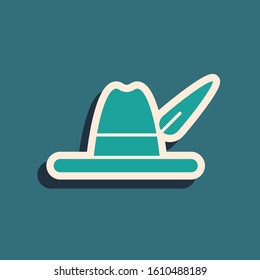 Green Oktoberfest hat icon isolated on blue background. Hunter hat with feather. German hat. Long shadow style. Vector Illustration