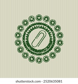 Green paper clip icon inside grunge seal. 