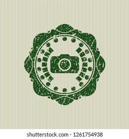 Green photo camera icon inside distressed rubber grunge texture stamp