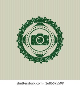 Icono de cámara fotográfica verde dentro de la estampilla de grunge de socorro