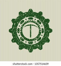 Green pickaxe icon inside distressed rubber stamp