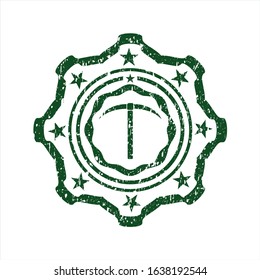 Green pickaxe icon inside rubber grunge seal