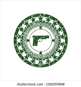 Green pistol icon inside distressed rubber seal with grunge texture