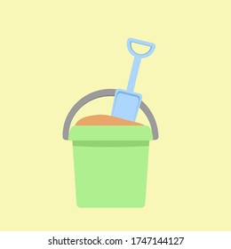 Green plastic bucket with a blue spatula that is stuck in the sand