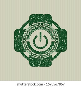 Green power icon inside rubber grunge stamp