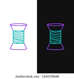 Green and purple line Sewing thread on spool icon isolated on white and black background. Yarn spool. Thread bobbin.  Vector Illustration