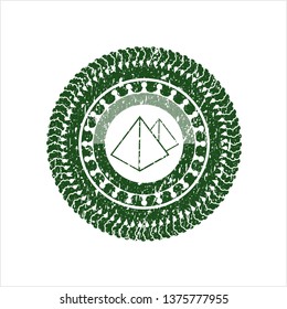 Green pyramids icon inside distress rubber seal with grunge texture