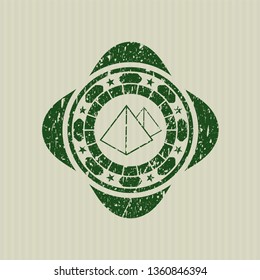 Green pyramids icon inside grunge stamp