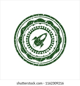 Green rocket icon inside distress rubber stamp with grunge texture