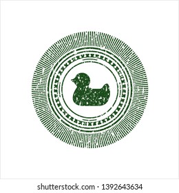 Green rubber duck icon inside rubber seal with grunge texture