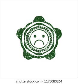 Green sad face icon inside distress rubber grunge stamp