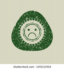 Green sad face icon inside distress rubber grunge texture seal