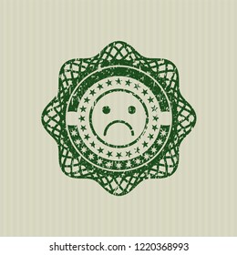 Green sad face icon inside distressed grunge stamp