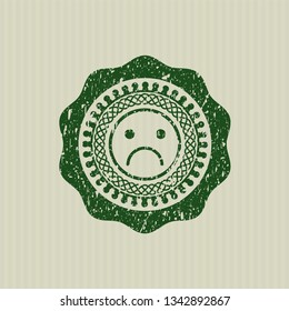 Green sad face icon inside rubber grunge stamp