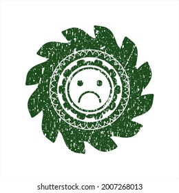 Green sad face icon inside distressed grunge stamp. 