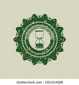 Green sand clock icon inside grunge seal