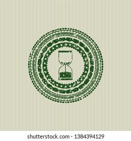 Green sand clock icon inside distressed rubber grunge stamp