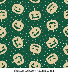 Green seamless pattern with beige scary pumpkin and dots.