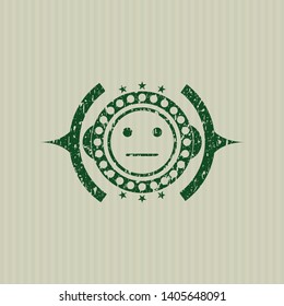 Green serious face icon inside distressed grunge style stamp