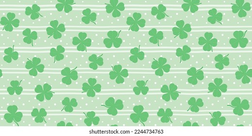 Green shamrocks and clover leaves on a pale green striped background with dots. St. Patrick's Day endless texture. Vector seamless pattern for wrapping paper, giftwrap, cover, surface texture or print