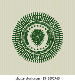 Green shield icon inside distress rubber stamp with grunge texture