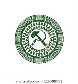 Green sickle and hammer icon inside distressed rubber stamp