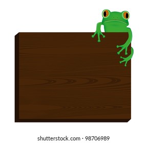 Green tree frog sitting on wood background