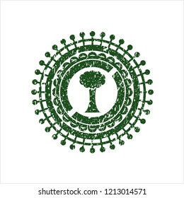 Green tree icon inside distressed rubber grunge seal