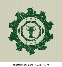 Green trophy icon inside distressed rubber seal with grunge texture