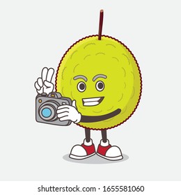 Green Tropical Fruit cartoon mascot character as photographer in action with a camera