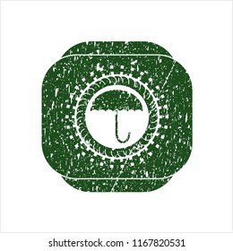 Green umbrella icon inside distressed rubber grunge stamp