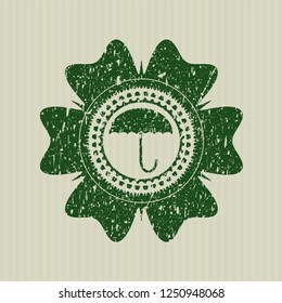Green umbrella icon inside distressed rubber grunge texture stamp