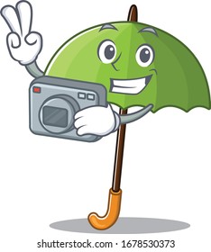 Green umbrella mascot design as a professional photographer with a camera