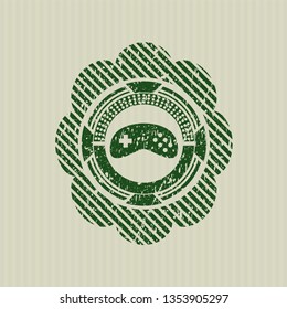 Green video game icon inside distressed rubber grunge texture stamp