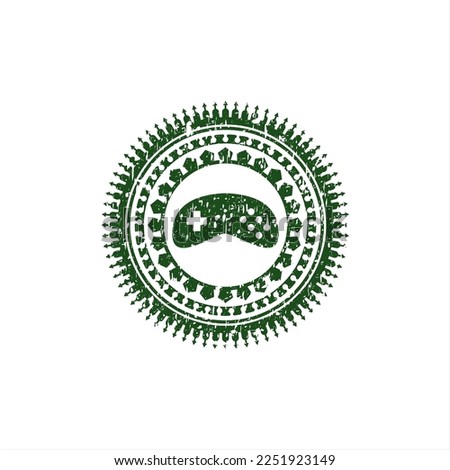 Green video game icon inside distressed rubber seal with grunge texture. 