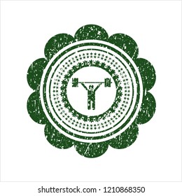 Green weightlifting icon inside distressed rubber grunge texture seal