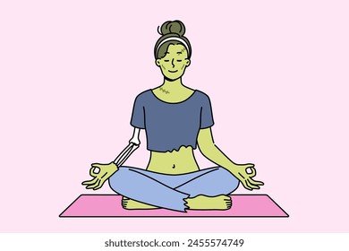 Bruja verde meditando en posición de loto haciendo yoga en halloween para restaurar la salud después de la resurrección. Mujer Frankenstein haciendo ejercicios de yoga con ganas de alcanzar la iluminación en la vida